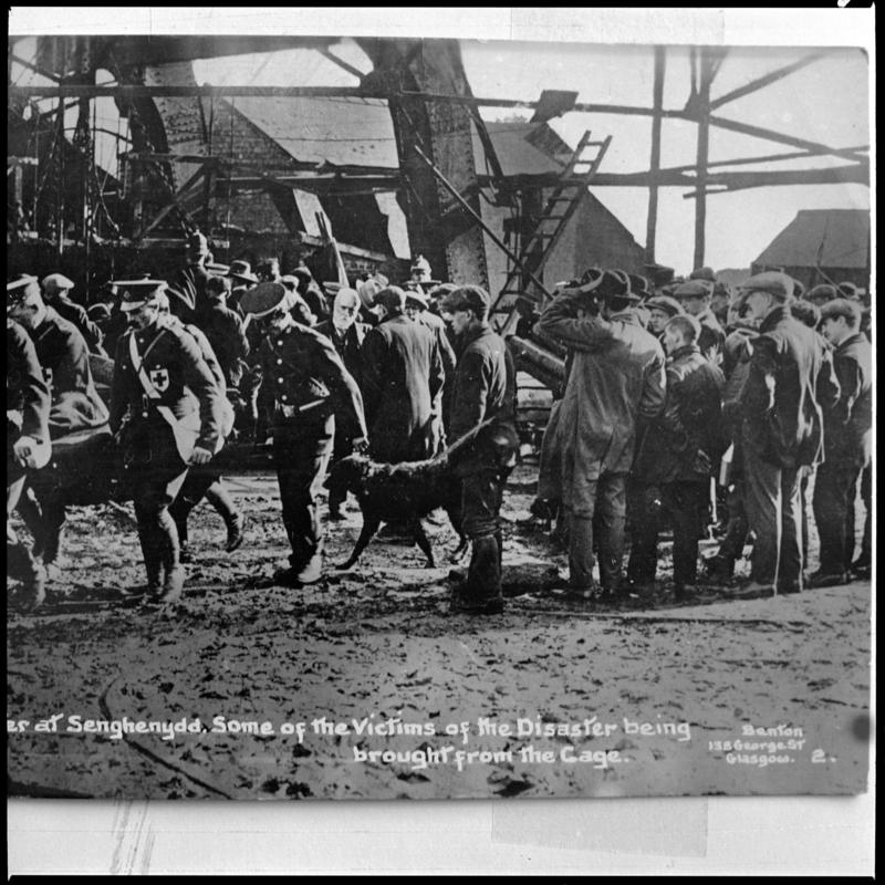 Black and white film negative of a photograph showing the scene at Universal Colliery, Senghenydd after the explosion of 14 October 1913.  Caption on photograph reads &#039;disaster at Senghenydd.  Some of the victims of the disaster being brought from the cage&#039;.  &#039;Senghenydd&#039; is transcribed from original negative bag.