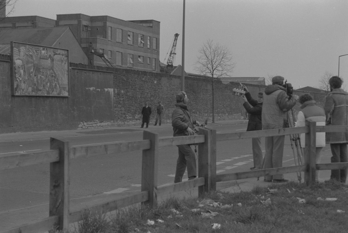 Film crew on Bute Street opposite mural on wall of railway embankment.