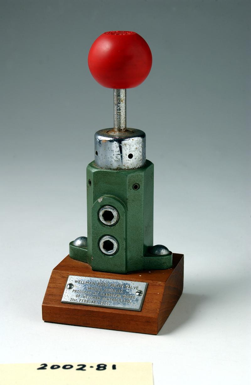 Valve on wooden plinth with plaque.