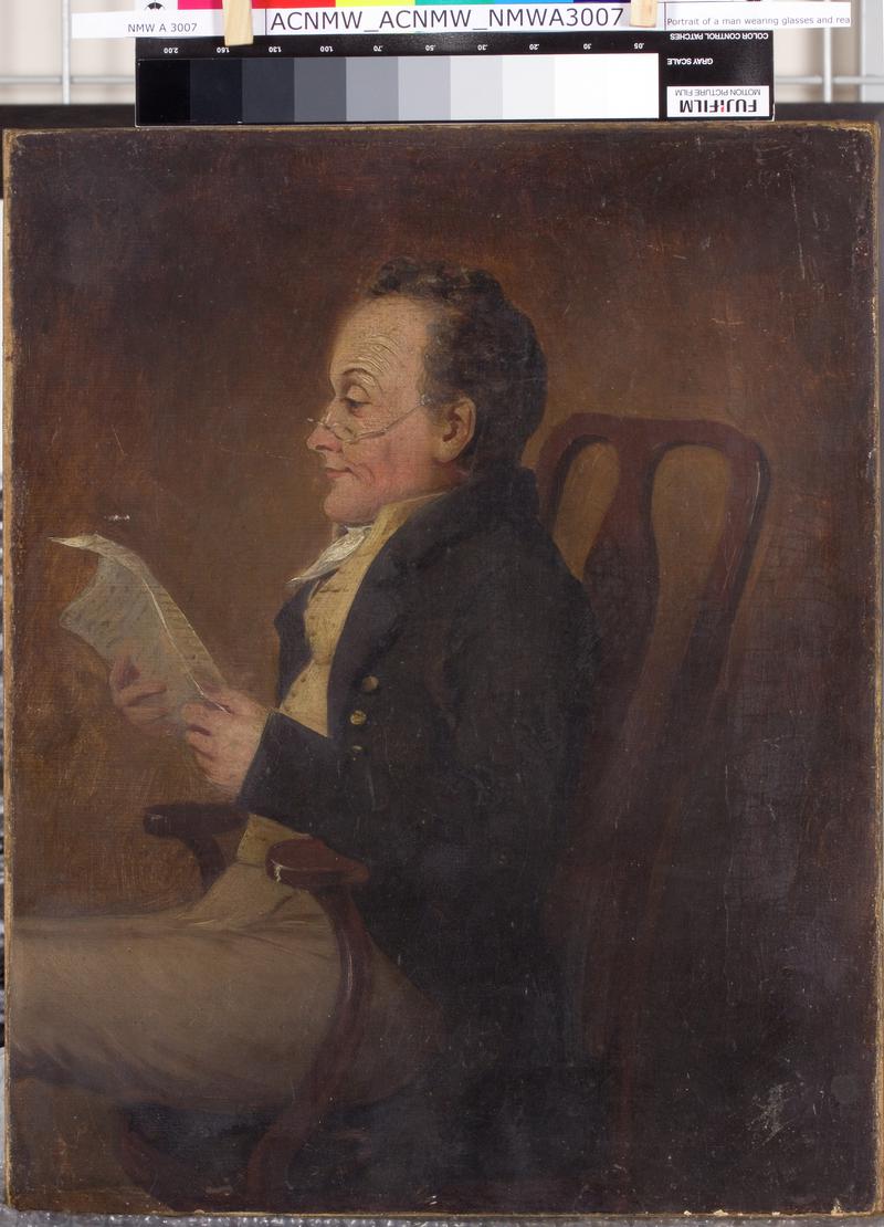 Portrait of a man wearing glasses and reading