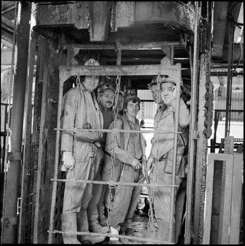 Black and white film negative showing miners in the cage at pit top, Merthyr Vale Colliery, 21 September 1981.  &#039;Merthyr Vale 21 Sep 1981&#039; is transcribed from original negative bag.
