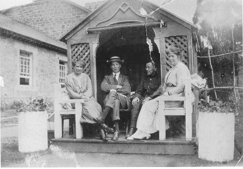 Dinorwig Quarry Hospital. Group of people sitting in a sun house outside DQH. Left to right: unidentified lady, Griffith Samuel Hughes, Florimond de Wulf (Vivian Hughes&#039; uncle), possibly DQH&#039;s sister.