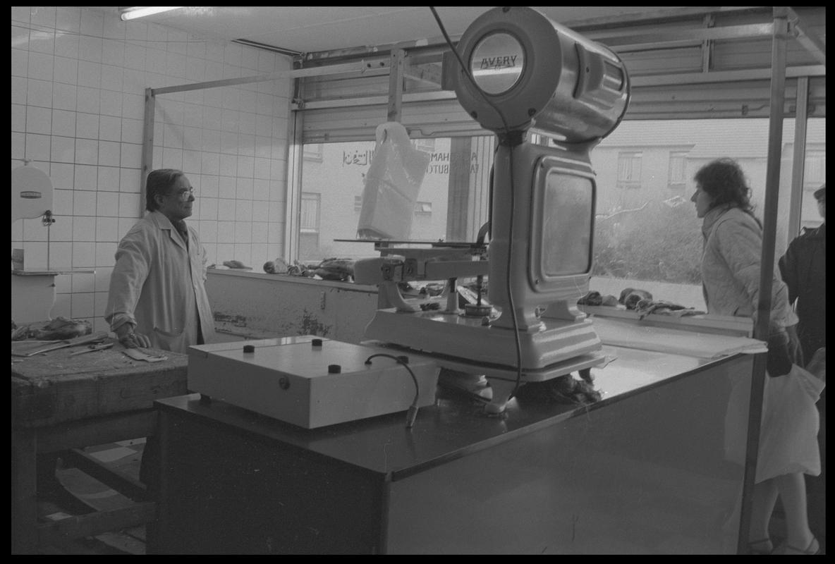 Customers in butcher shop, Loudoun Square, Butetown.