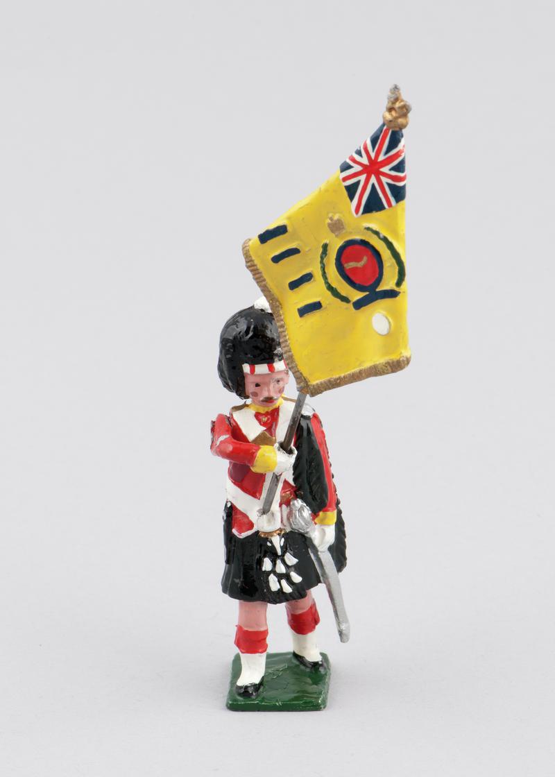 Model of an Argyll &amp; Sutherland Highlander holding regimental colours (yellow), 1914. Left arm holds removable flag. Arm is movable. Hand-painted.