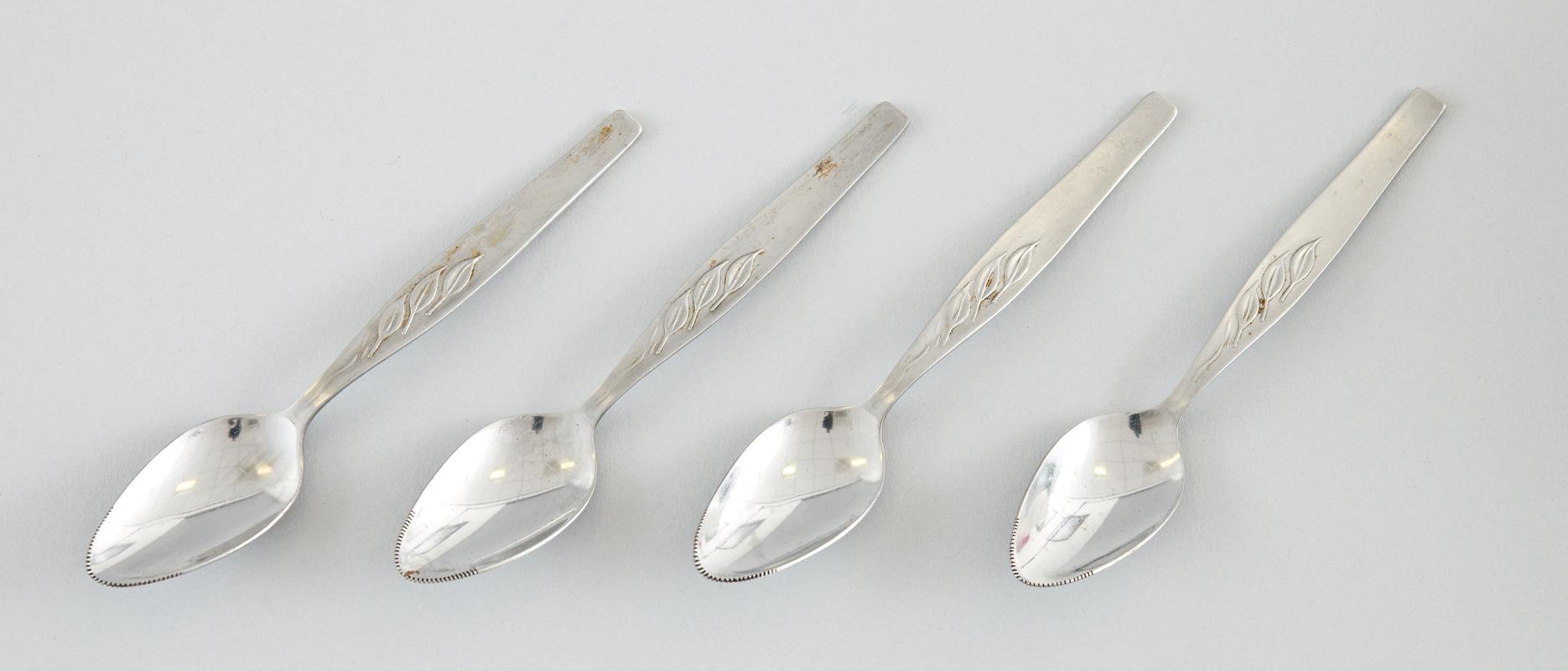 Four stainless steel grapefruit spoons, with serrated tip with leaf design on handle.