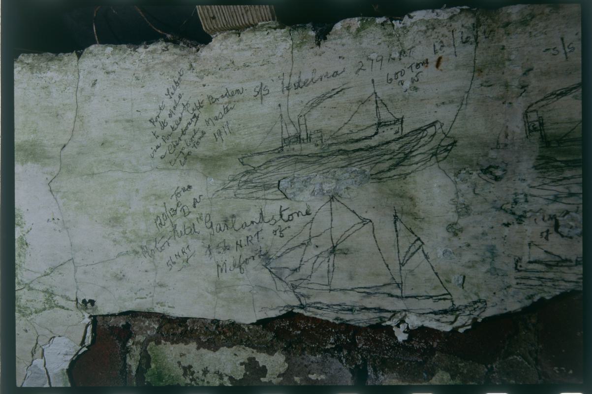 Graffitied tŷ bach in a garden in Trefin, slide