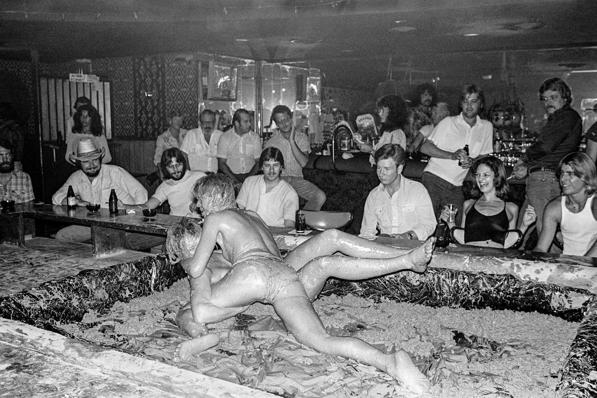 USA. ARIZONA. General. The Sand Box lounge in Phoenix. Mudwrestling. In theory no nudity allowed. Nipples must have tape over them but the type and size of the tape is not stipulated. 1980.