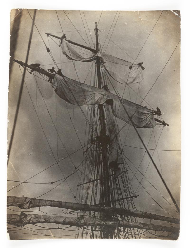 Crew of an unidentified sailing vessel bending a new top gallant sail.