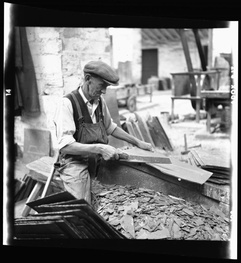Quarryman dressing a roofing slate using a slate trimming knife, &#039;cyllell naddu&#039;, Dinorwig Quarry, early 1960s.