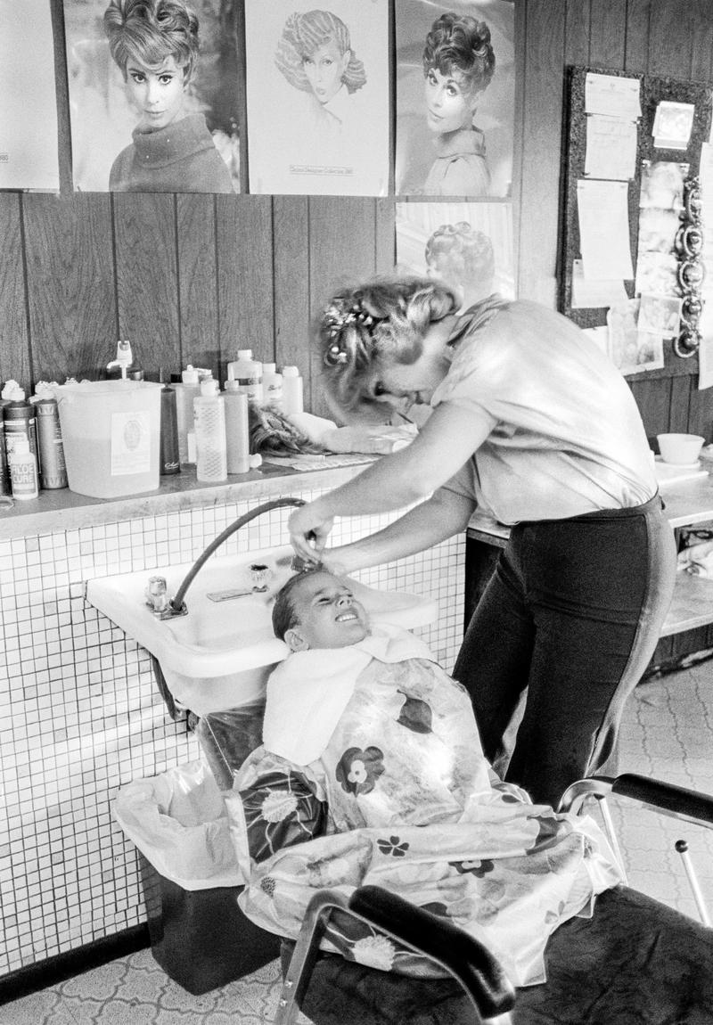 USA. ARIZONA. Local hairdresser dealing with young customer as though they were a grown-up in Paradise Valley. 1979.