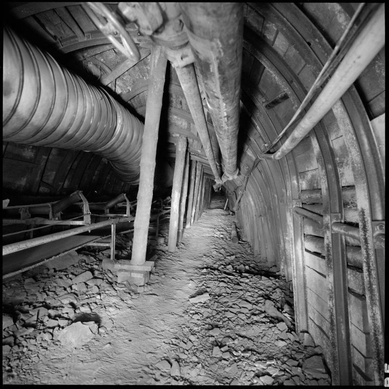 Black and white film negative showing an underground tunnel with high speed conveyor, Merthyr Vale Colliery 2 July 1981.  &#039;2 Jul 1981&#039; is transcribed from original negative bag.
