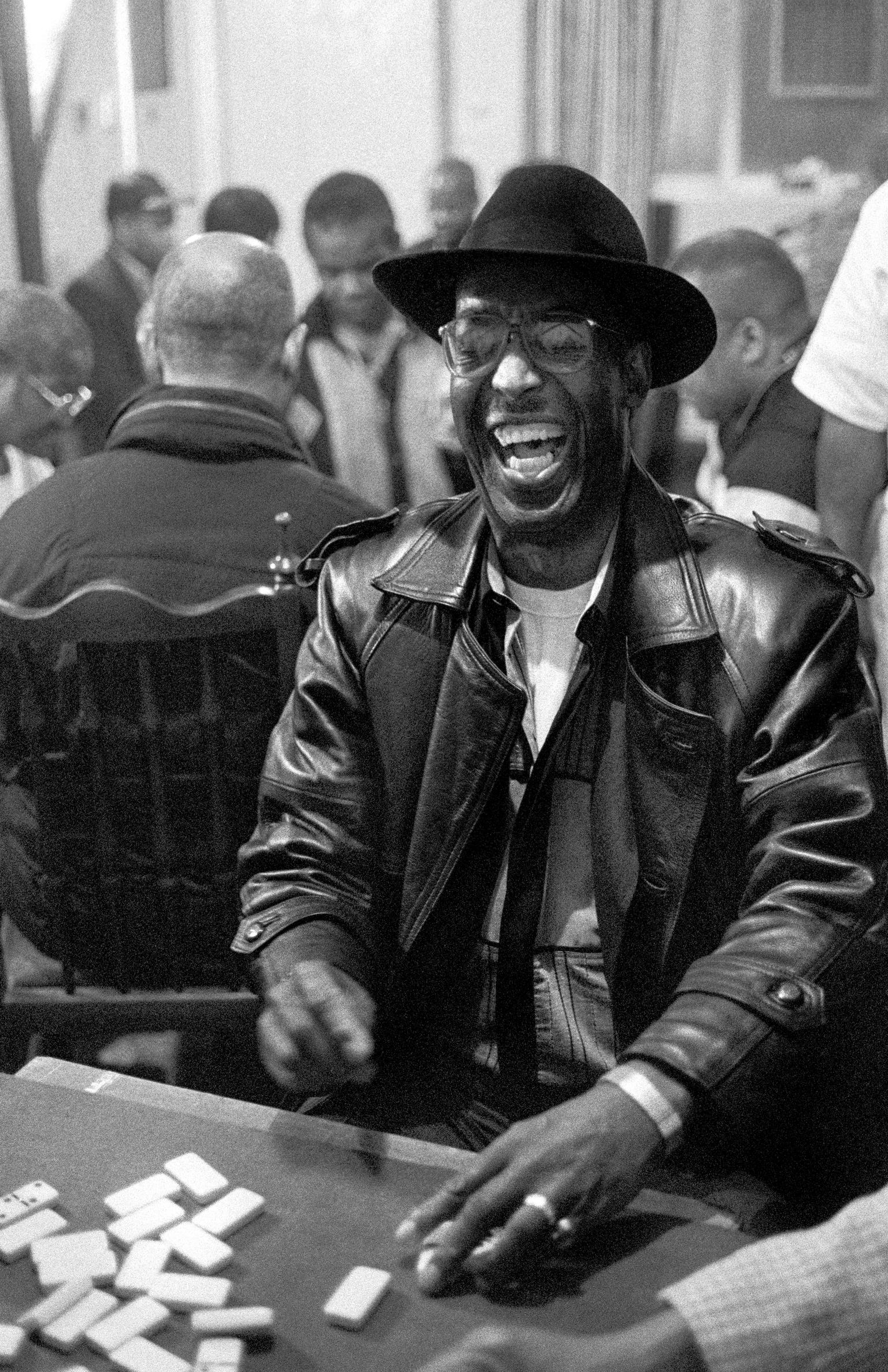 Enjoying a winning hand. A player laughing at a domino match between Cardiff and London held above Bab's Bistro