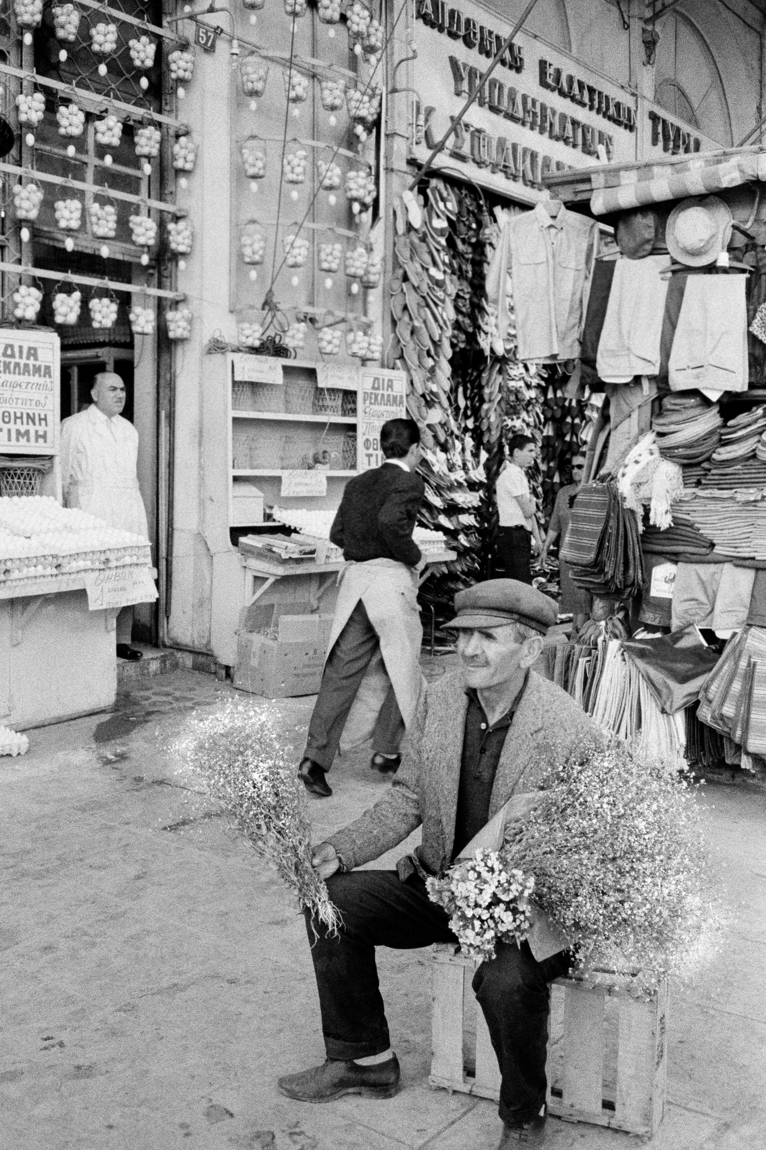 Street flower seller in front of the egg shop. Athens. Greece