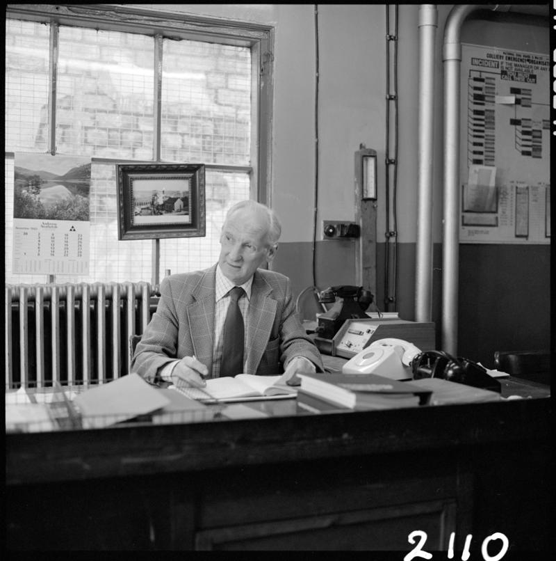 Black and white film negative showing Glyn Morgan, the final NCB manager, in his office at Big Pit Colliery, 28 November 1980.  &#039;Blaenavon 28/11/80 Glyn Morgan&#039; is transcribed from original negative bag.