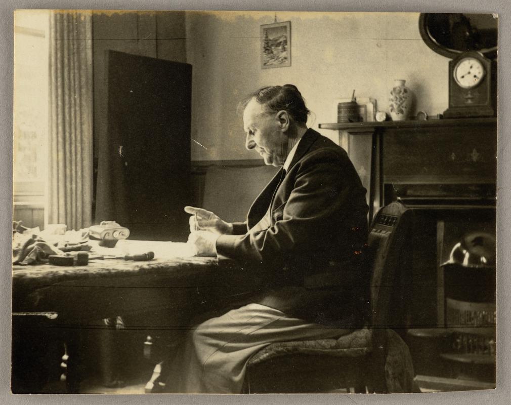 View of C.H. Watkins working at table at home.