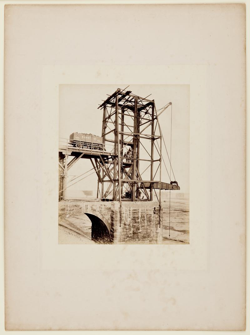 Construction of Barry No. 1 Dock showing nearly completed coal hoist. The full &quot;Barry Co.&quot; coal wagon is probably there for advanced publicity purposes. Mounted on card.