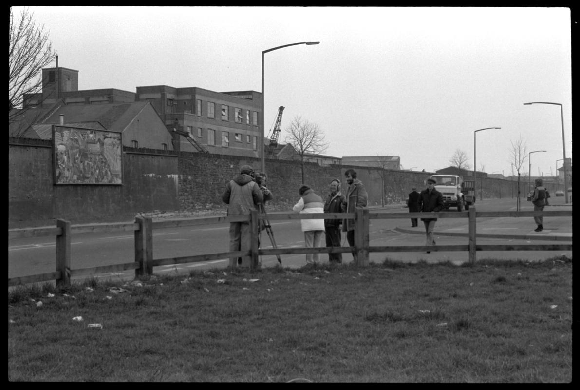 Film crew on Bute Street opposite mural on wall of railway embankment.