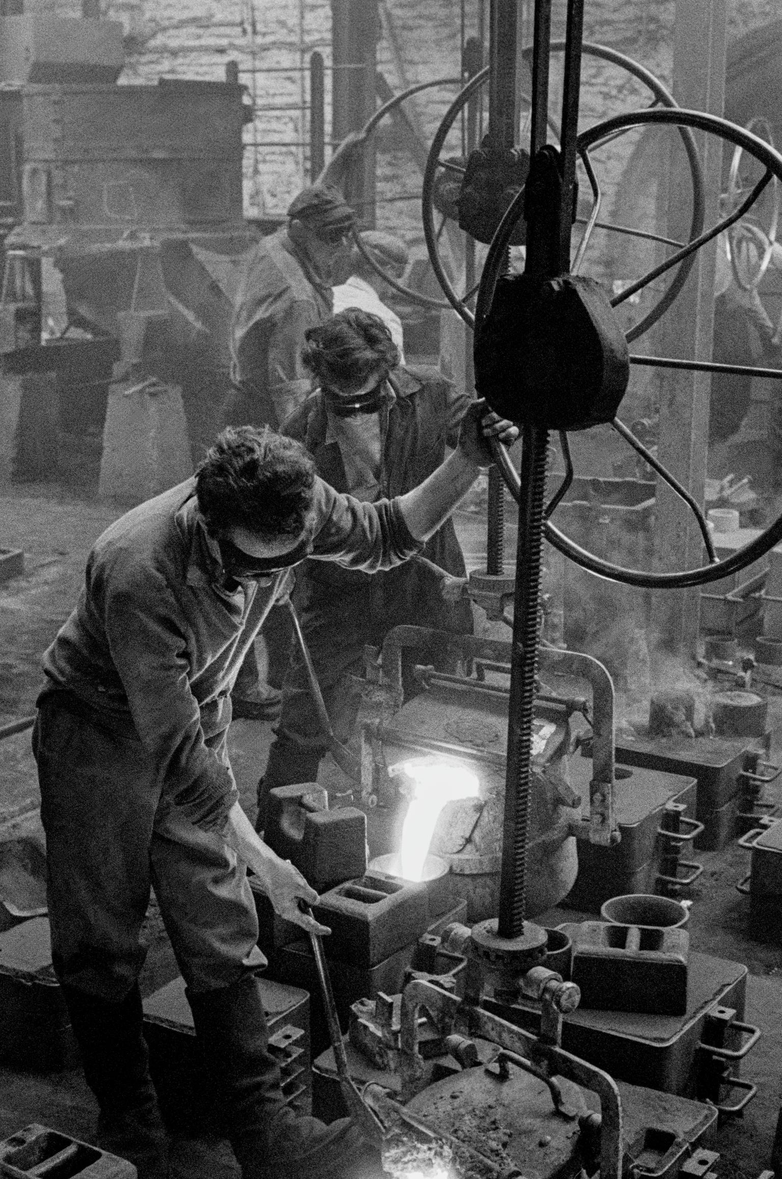 Men casting in the Metal Box factory. Working in the steel industry is very dangerous work. Neath, Wales