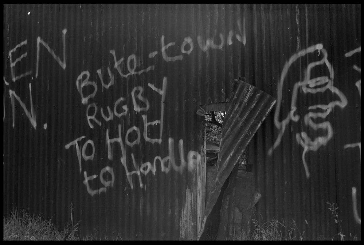 Graffitti on corrugated iron fence in Butetown.