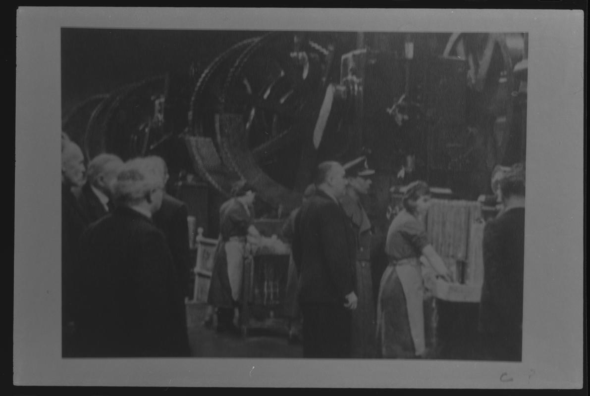 Film negative of a photograph showing visit of King George VI and Queen Elizabeth to Currans, Butetown during World War II. King talking to officials.