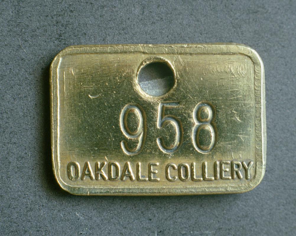 Colour film slide showing an Oakdale Colliery lampcheck engraved &#039;958 OAKDALE COLLIERY&#039;.