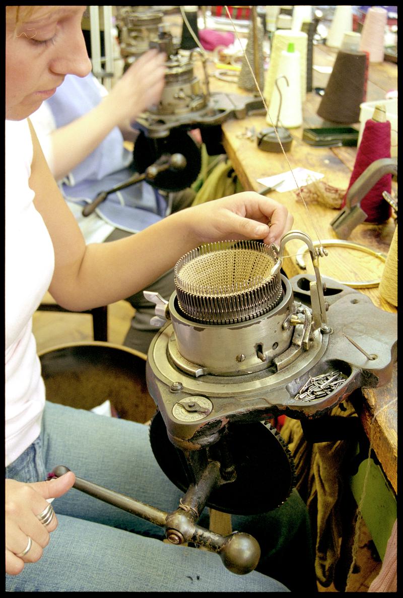 Worker knitting a broad rib pattern on top of stock foot at Corgi Hosiery Ltd factory, Ammanford, 1 July 2002.