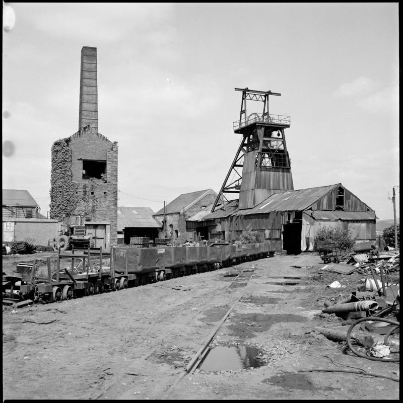 Black and white film negative showing a surface view of Morlais Colliery, including the derelict pumping house which contained a beam pump.
