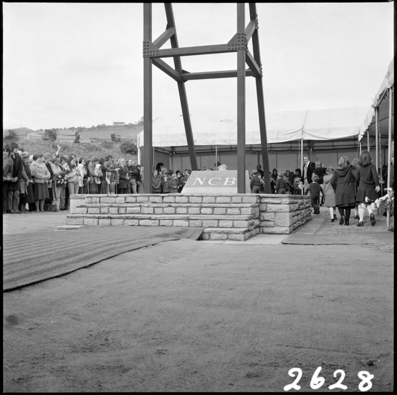 Black and white film negative showing the unveiling ceremony of the Senghenydd memorial, commemorating the 1913 Universal Colliery explosion.  The negative is undated but the ceremony took place in October 1981. &#039;Senghenydd&#039; is transcribed from original negative bag.