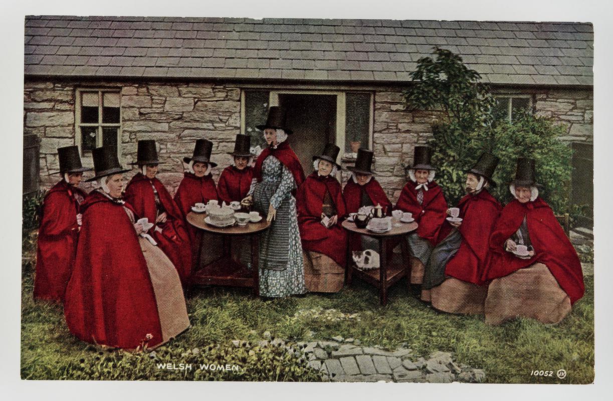 Group of 11 Welsh women having tea outside a stone cottage