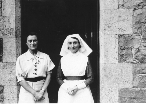 Dinorwig Quarry Hospital. Marie Therese Hughes and one of the DQH nurses, standing outside the side entrance to DQH (entrance to the private part of the hospital)