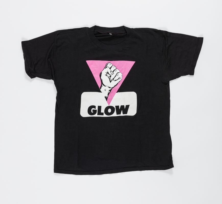 Black t-shirt with a raised fist within a pink triangle and words &#039;GLOW&#039; on front, and &#039;SPEAKING FOR OURSELVES&#039; on the back.