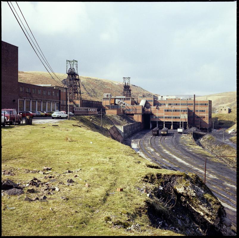 Colour film negative showing a general surface view of Maerdy Colliery.  The brick structure over the railway sidings is the washery.