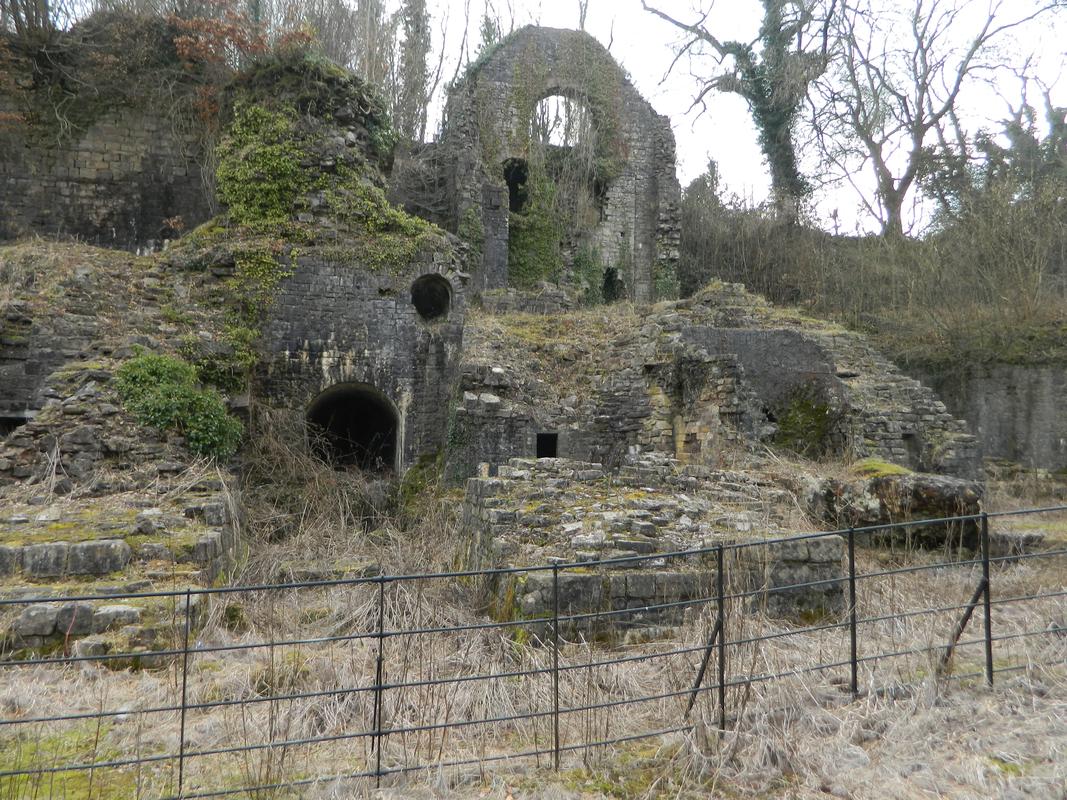 Clydach Ironworks: remains of no.1 furnace on right with arch of charging house above in background, viewed from south west.