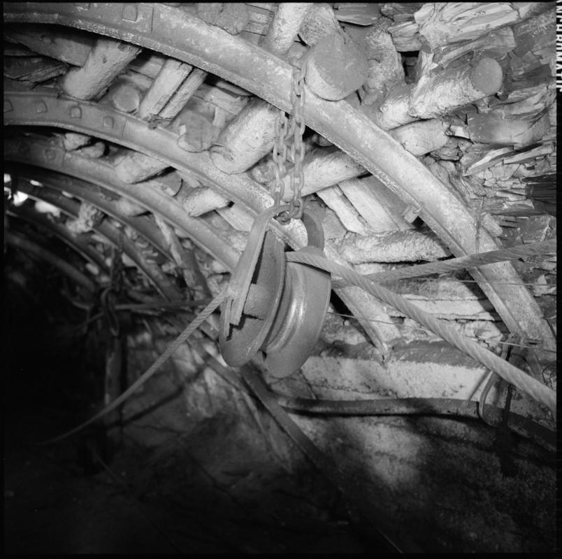 Black and white film negative showing a pulley and haulage rope, underground at Wyndham Western Colliery. &#039;Wyndham Western&#039; is transcribed from original negative bag.