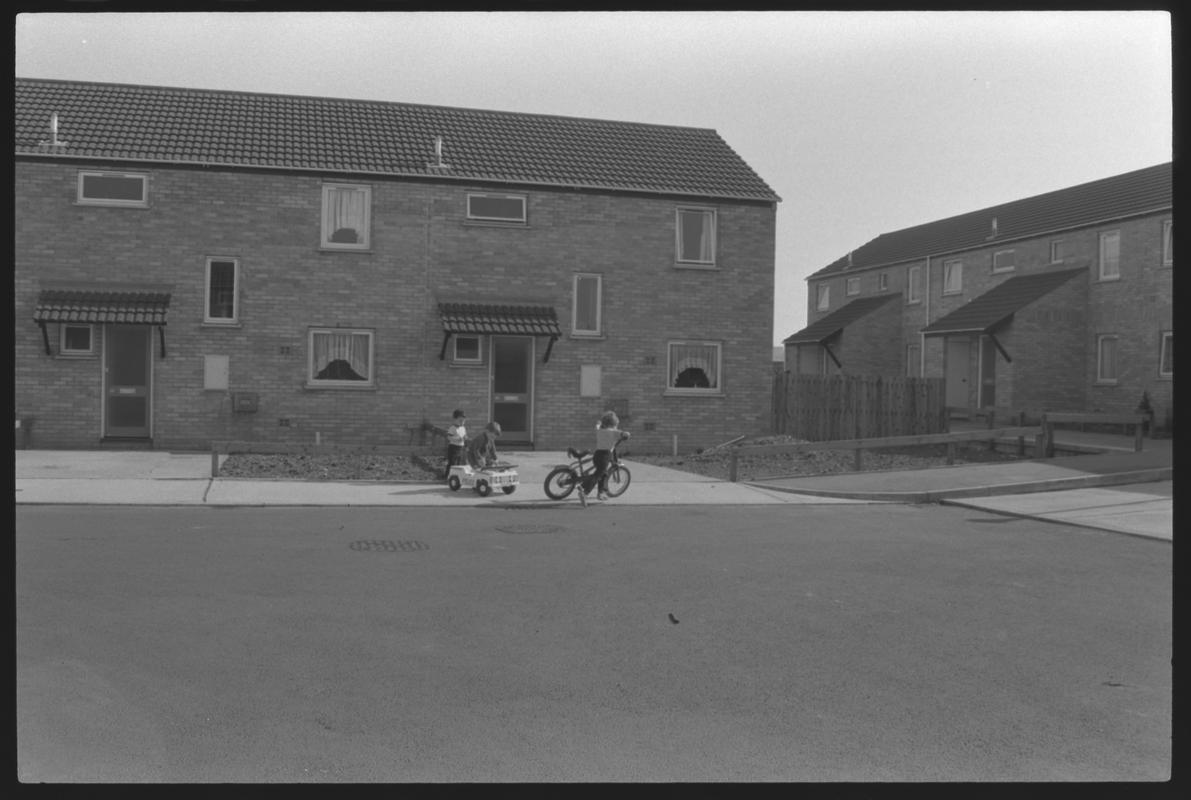 Children on bikes outside new houses at Eleanor Place, Butetown.