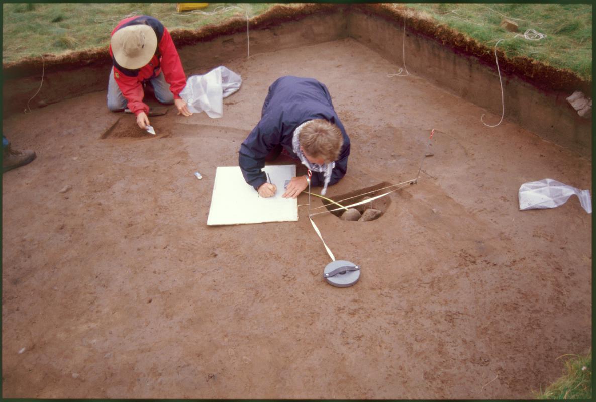 Burry Holms, Gower. 2000 Trench 4. Sectioned posthole 60 being planned and drip gully context 54 being excavated. Looking south-east.