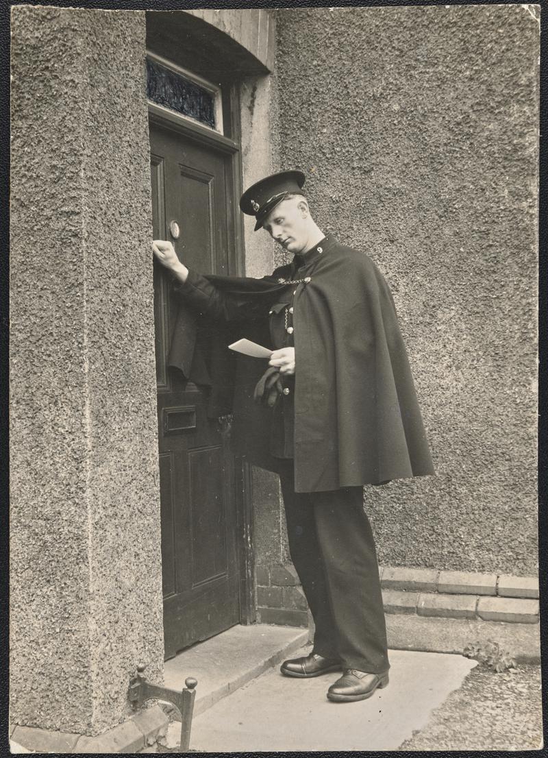 Policeman knocking at door of home