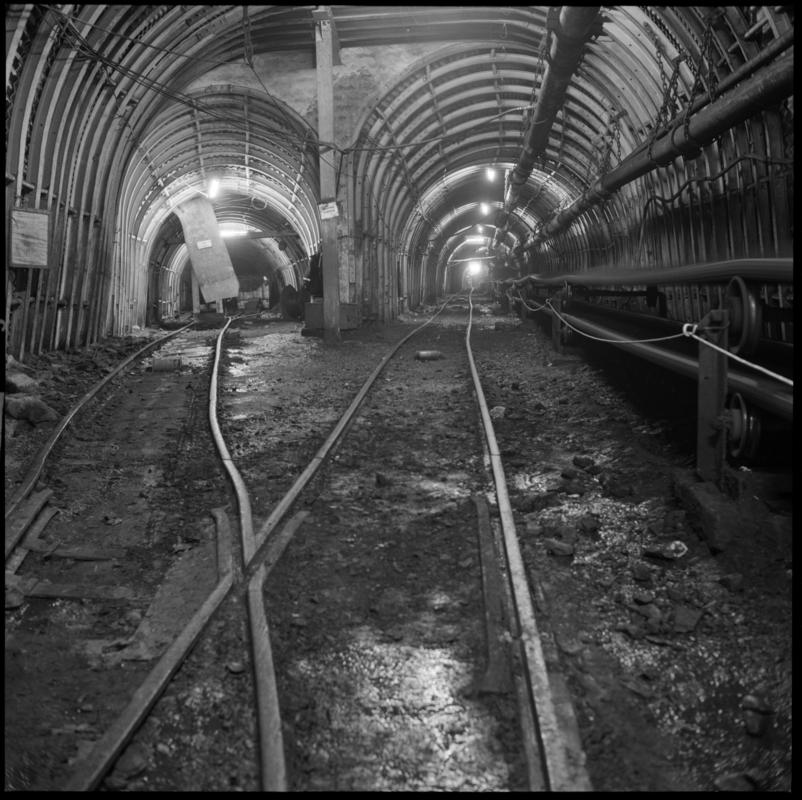 Black and white film negative showing a junction in a new underground development, 1977.  A high speed cable belt can be seen on the right of the picture.  Similar image to 2009.3/92.