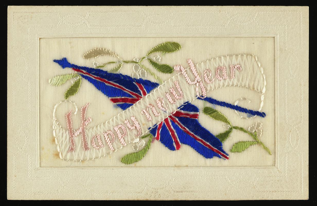 Embroidered silk postcard inscribed Happy new year. Sent from France by either Gordon Hobbs or Tom Hardiman during First World War. Undated. Embroidered with Union flag and mistletoe. No message on back.