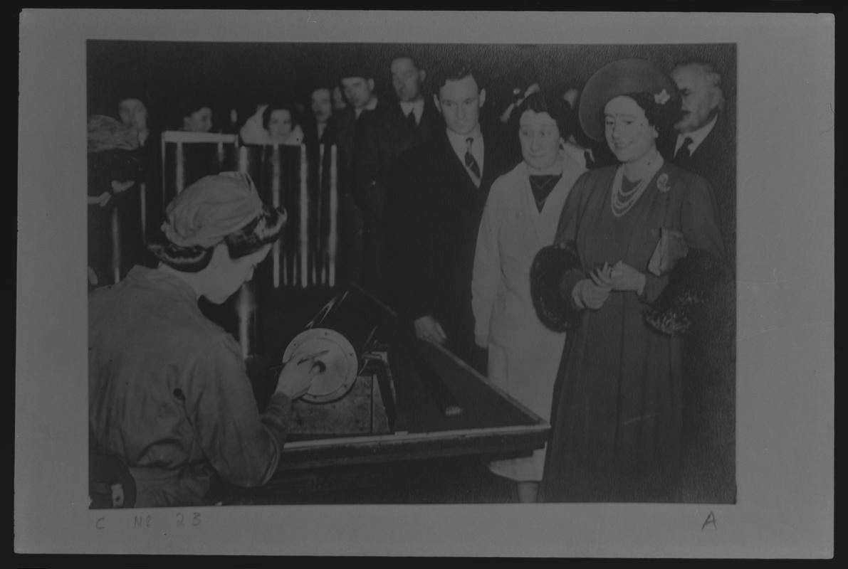 Film negative of a photograph showing visit of King George VI and Queen Elizabeth to Currans, Butetown during World War II. Queen talking to a member of staff.