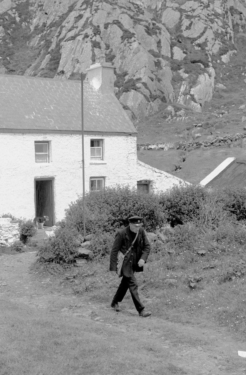 IRELAND. Kenmare. County Kerry. The local postman and a peripheral cottage. 1968.
