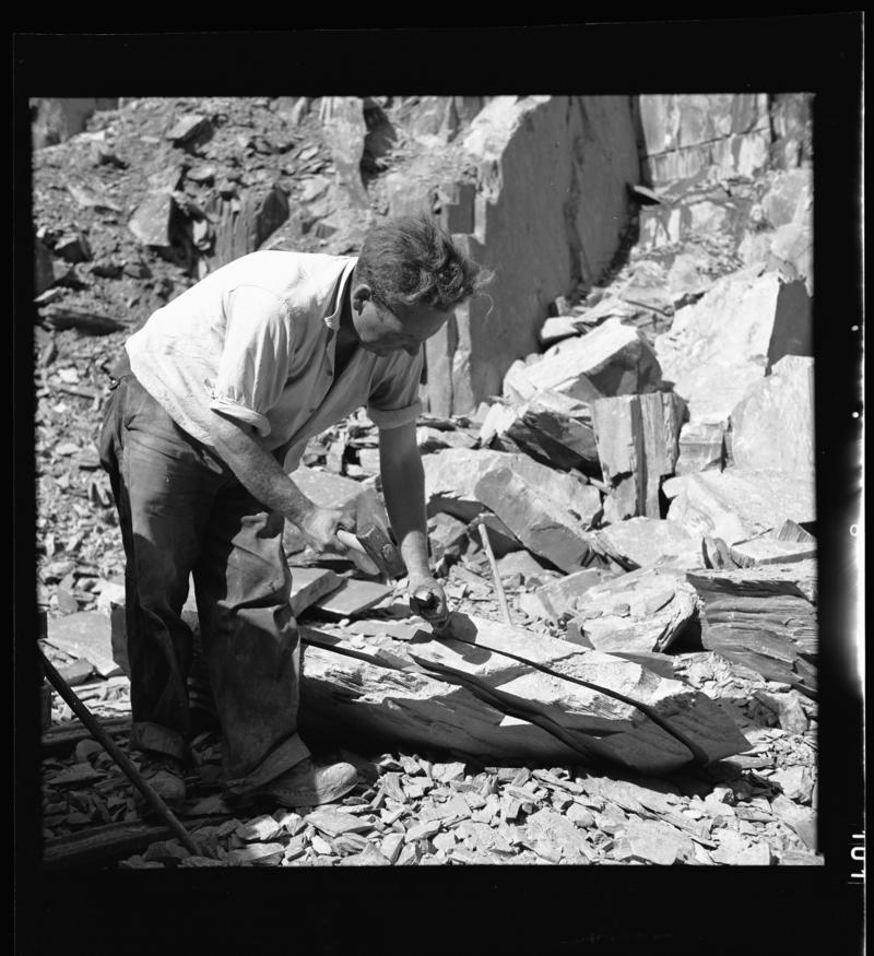 Quarryman preparing a large section of rock to be transported to the slate splitting and slate dressing sheds - &#039;bras hollti plyg&#039;,  Dinorwig Quarry, early 1960s.