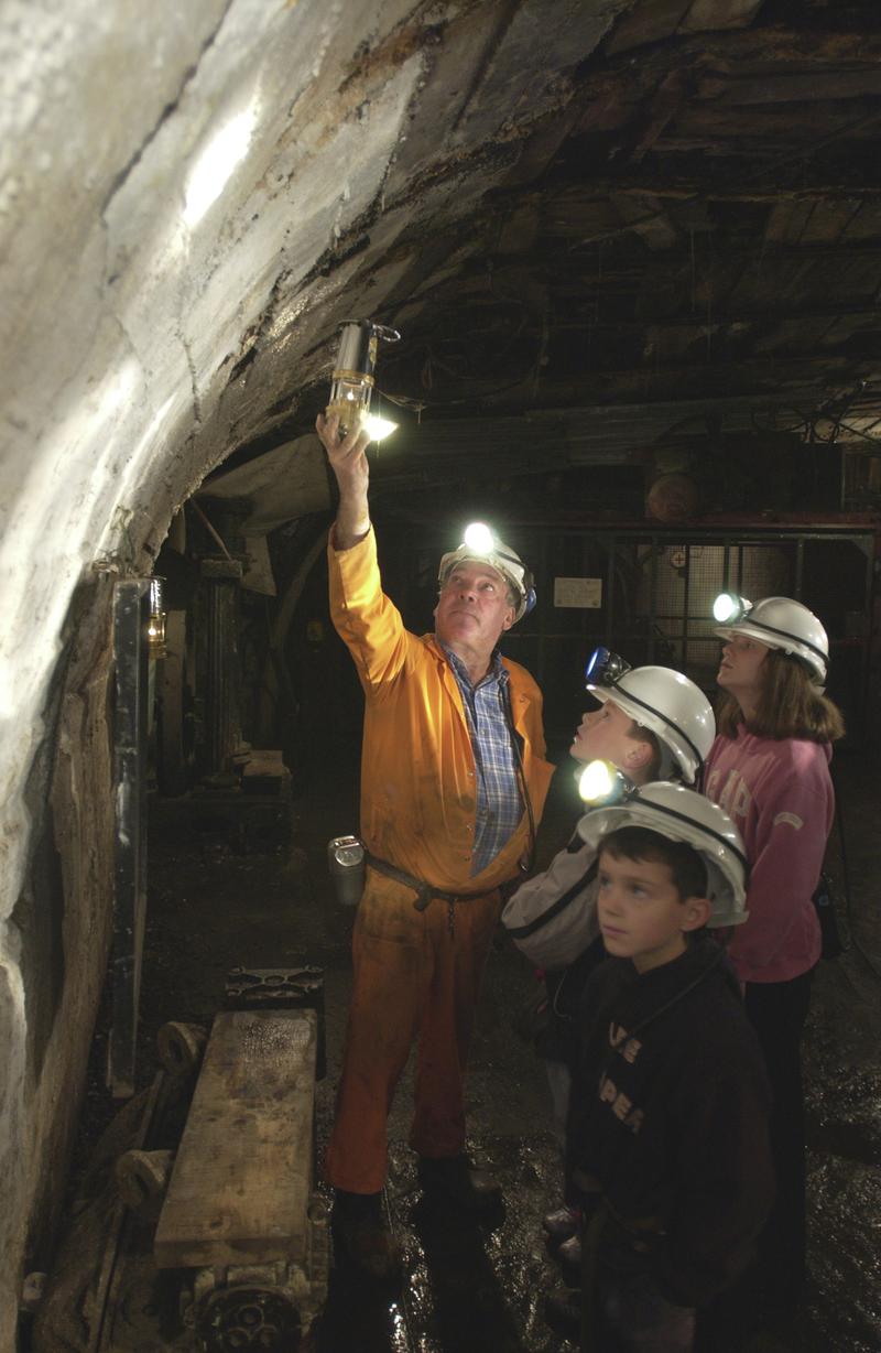 Miner guide with children on underground tour at Big Pit