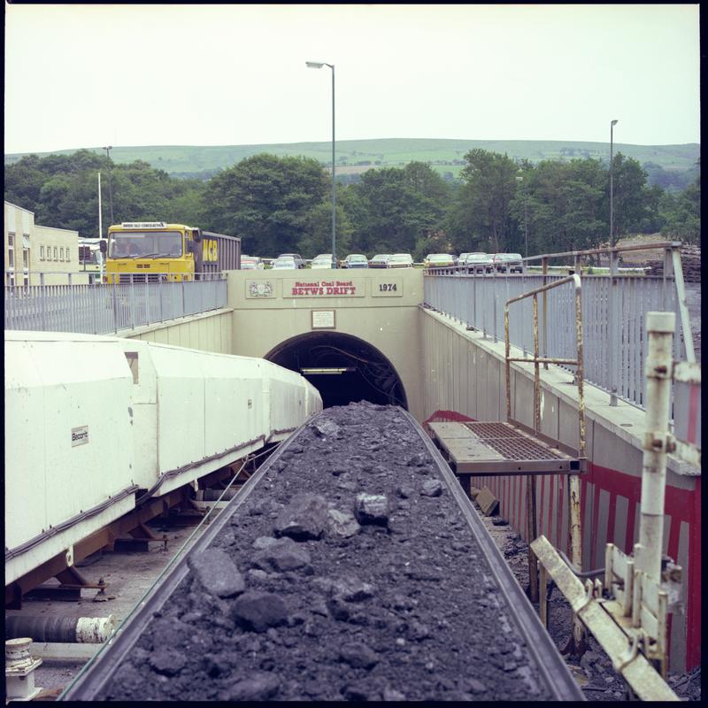 Colour film negative showing the entrance to the mine with man riding cars and conveyor, Betws Mine 10 June 1982.  &#039;10 June 1982&#039; is transcribed from original negative bag.