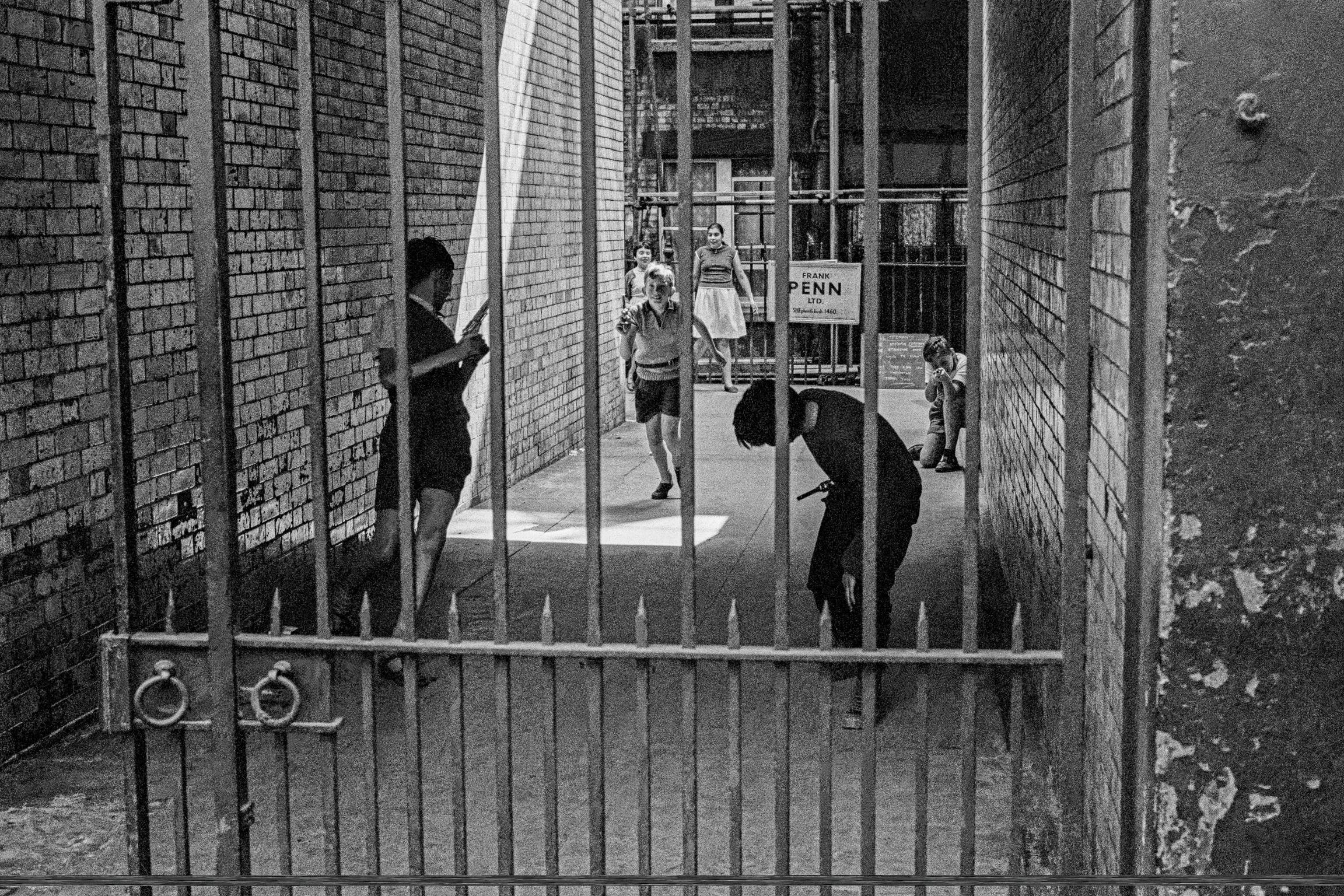 Street scene in Soho in the centre of London. Children play in the courtyard of a block of council flats