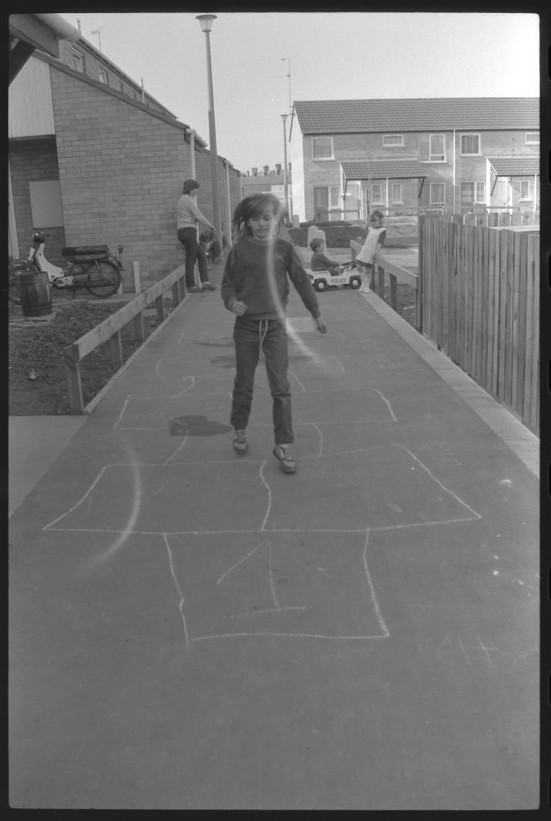 Child playing hopscotch at Eleanor Place, Butetown.