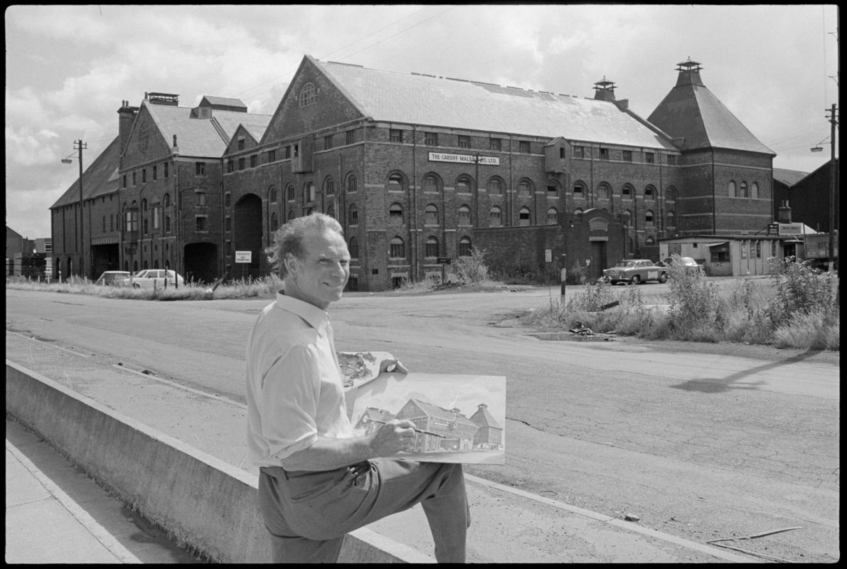 The buildings of the Cardiff Malting Co. Ltd with Mr C. Stevens painting a picture in the foreground.