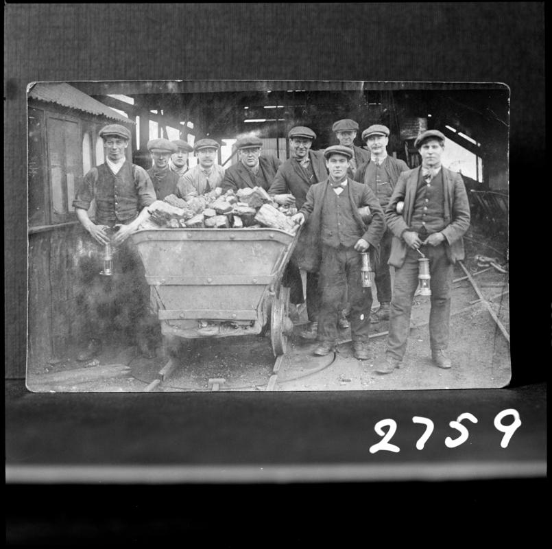 Black and white film negative of a photograph showing a group of miners gathered around a coal dram.  Appears to be identical to 2009.3/2236.