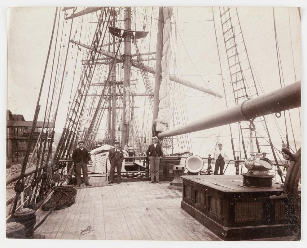 Captain J. Parry, and three other men, on the deck of the four masted barque TWEEDSDALE.