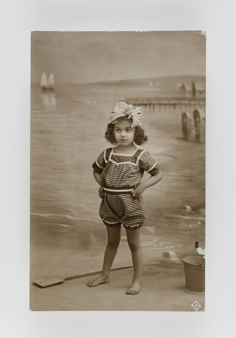 Photograph of a young girl in bathing costume.  Postmark:  New Quay, Cardiganshire.